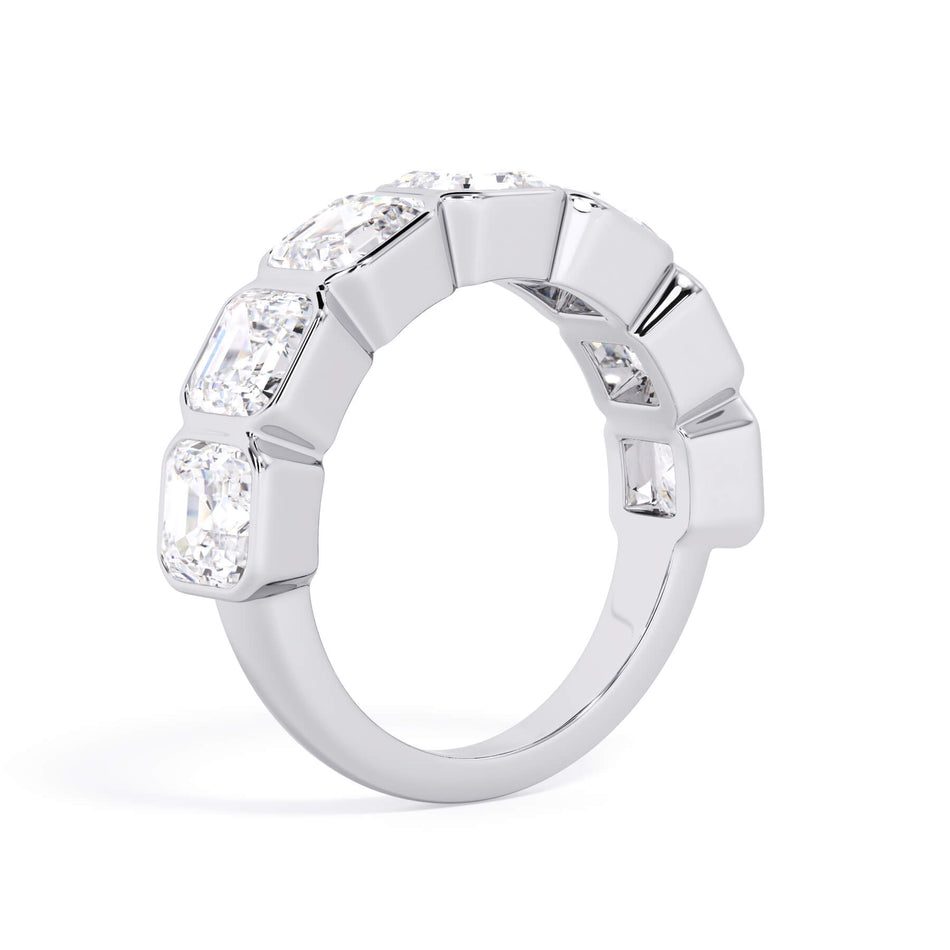 A picture of a seven stone diamond wedding ring with asscher cut diamonds that are bezel set in white gold or platinum on a white background with a slightly angled, through the finger view.