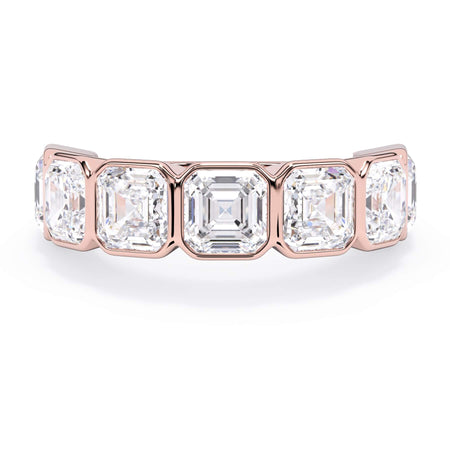A picture of a seven stone diamond wedding ring with asscher cut diamonds that are bezel set in rose gold on a white background with the ring facing forward, lying down.