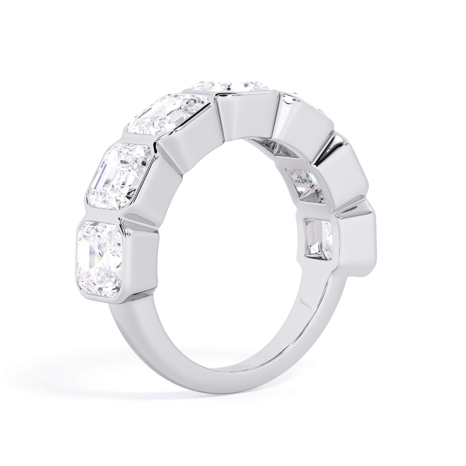 A picture of a seven stone diamond wedding ring with asscher cut diamonds that are bezel set in white gold or platinum on a white background with a slightly angled, through the finger view.