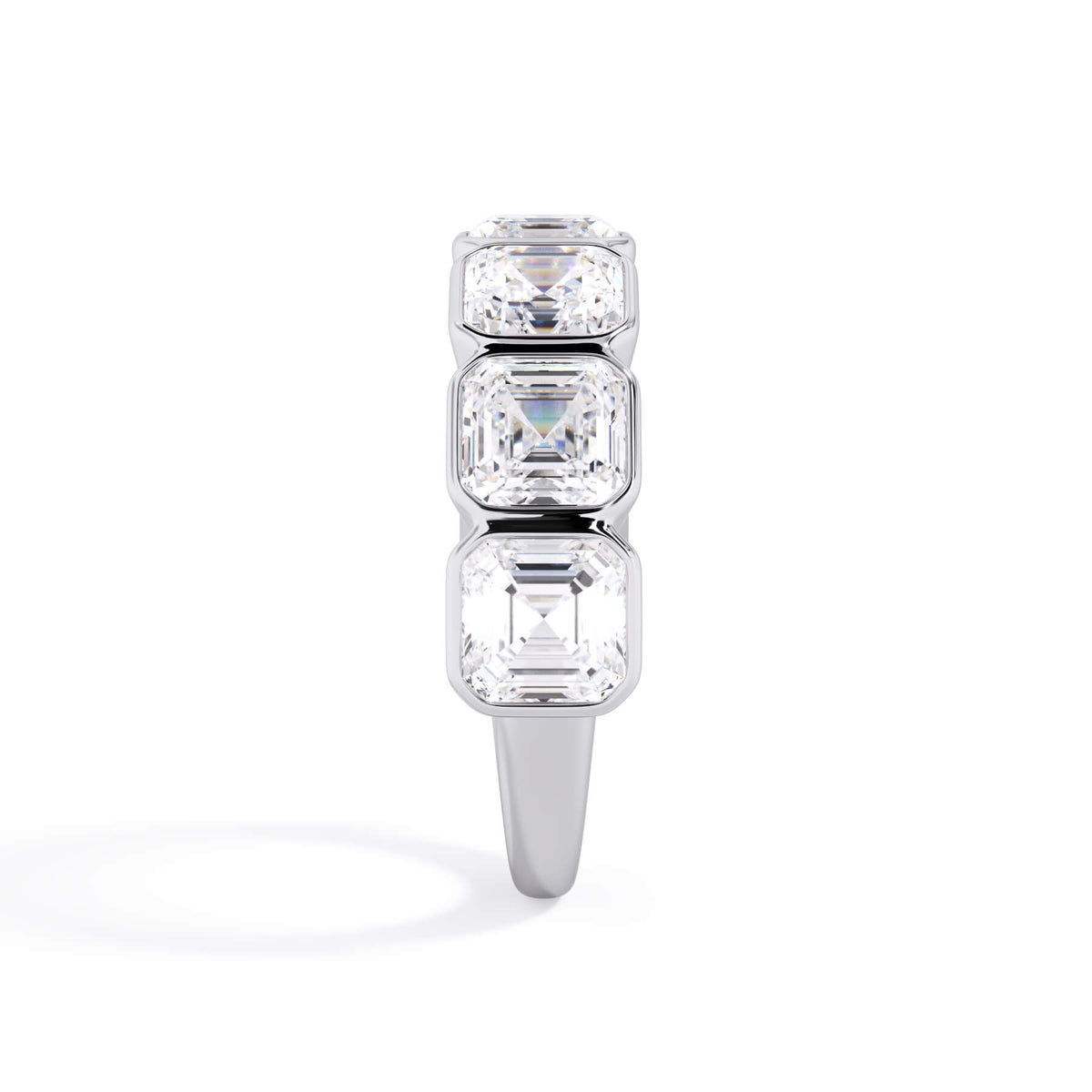 A picture of a seven stone diamond wedding ring with asscher cut diamonds that are bezel set in white gold or platinum on a white background with a side profile view.