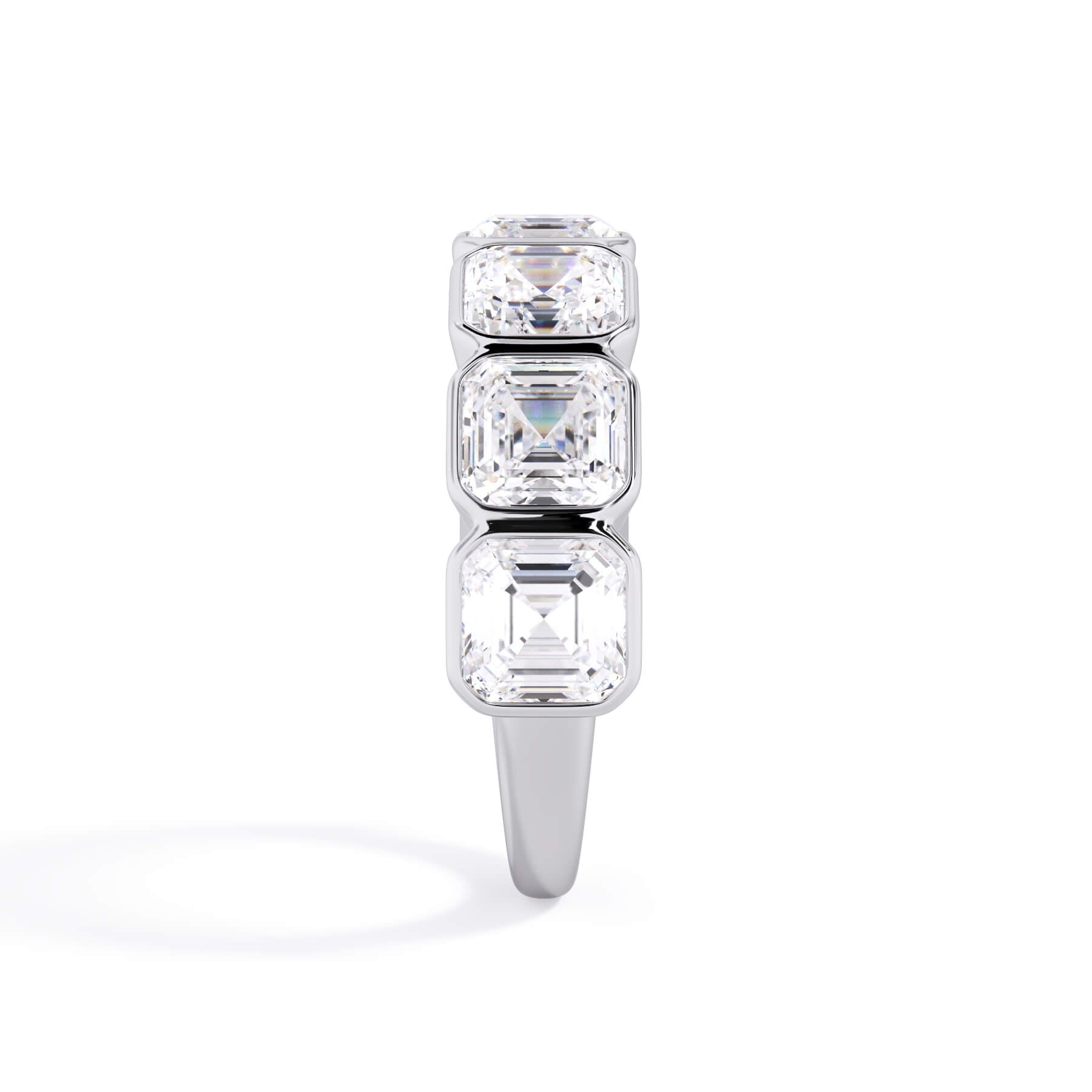 A picture of a seven stone diamond wedding ring with asscher cut diamonds that are bezel set in white gold or platinum on a white background with a side profile view.