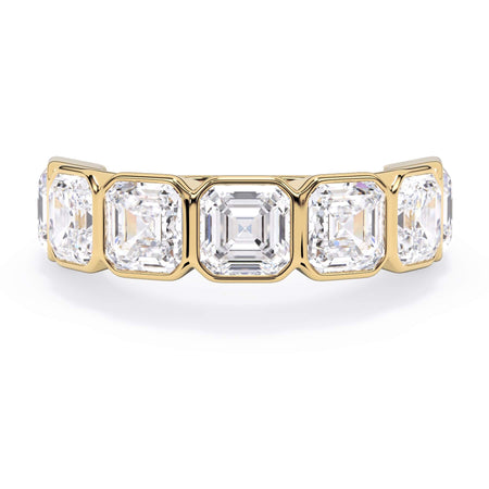A picture of a seven stone diamond wedding ring with asscher cut diamonds that are bezel set in yellow gold on a white background with the ring facing forward, lying down.