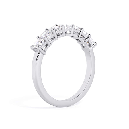 A picture of a seven stone diamond wedding ring with asscher cut diamonds that are shared prong set in white gold or platinum on a white background with a slightly angled, through the finger view.