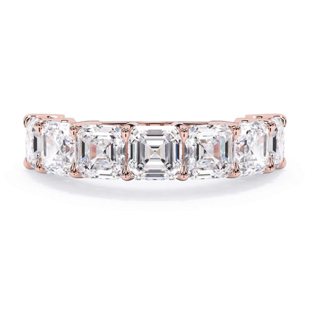 A picture of a seven stone diamond wedding ring with asscher cut diamonds that are shared prong set in rose gold on a white background with the ring facing forward, lying down.