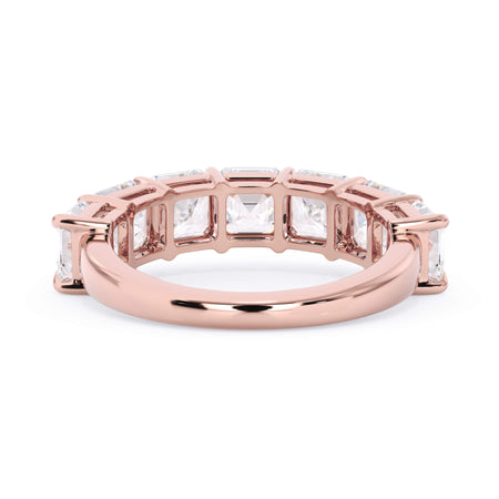 A picture of a seven stone diamond wedding ring with asscher cut diamonds that are shared prong set in rose gold on a white background with a view of the underside of the ring.