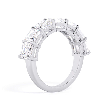 A picture of a seven stone diamond wedding ring with asscher cut diamonds that are shared prong set in white gold or platinum on a white background with a slightly angled, through the finger view.
