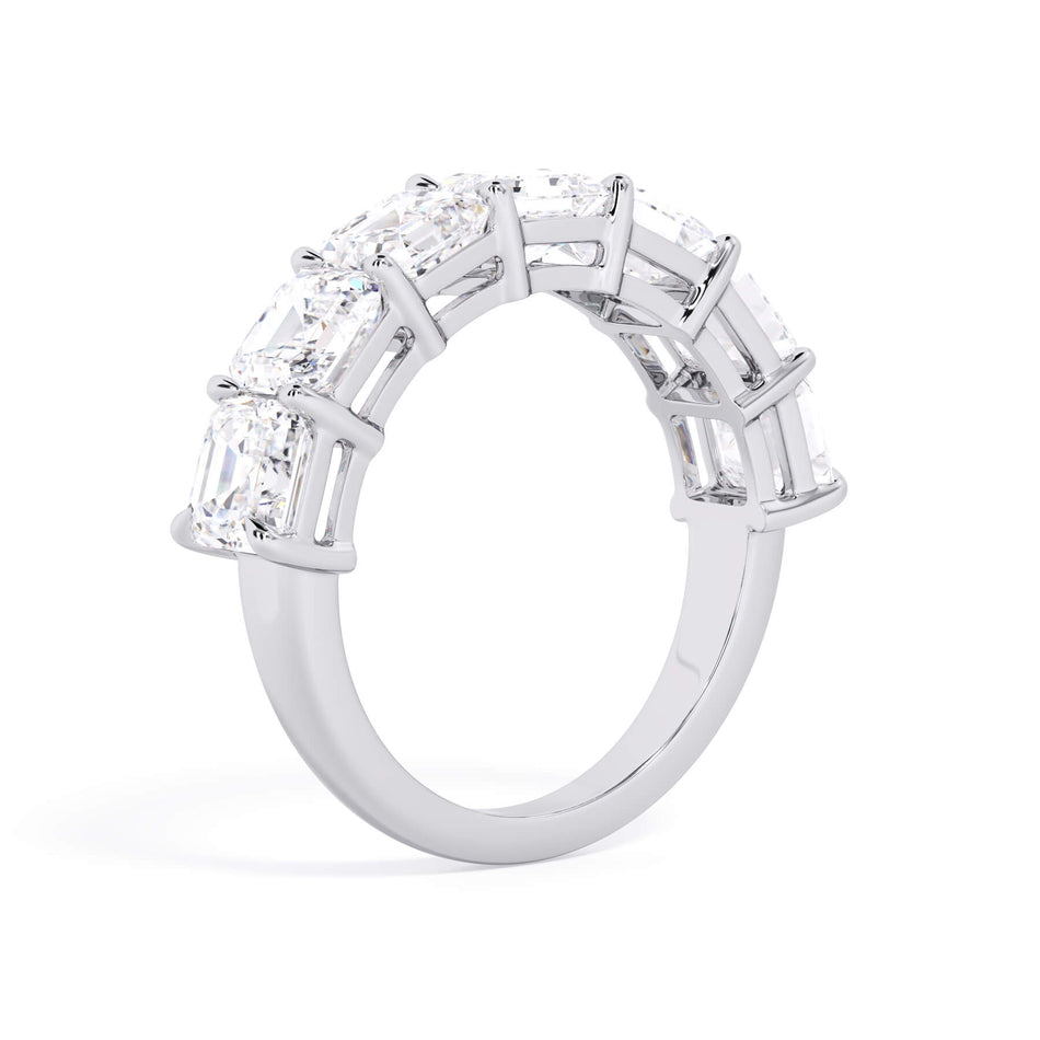 A picture of a seven stone diamond wedding ring with asscher cut diamonds that are shared prong set in white gold or platinum on a white background with a slightly angled, through the finger view.