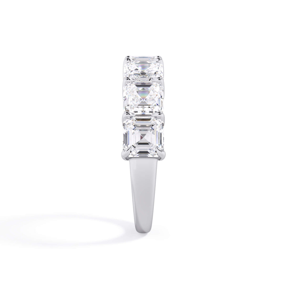 A picture of a seven stone diamond wedding ring with asscher cut diamonds that are shared prong set in white gold or platinum on a white background with a side profile view.