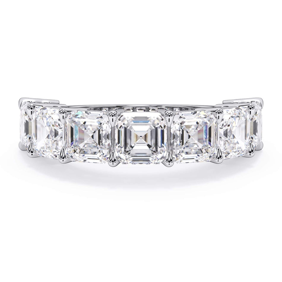 A picture of a seven stone diamond wedding ring with asscher cut diamonds that are shared prong set in white gold or platinum on a white background with the ring facing forward, lying down.