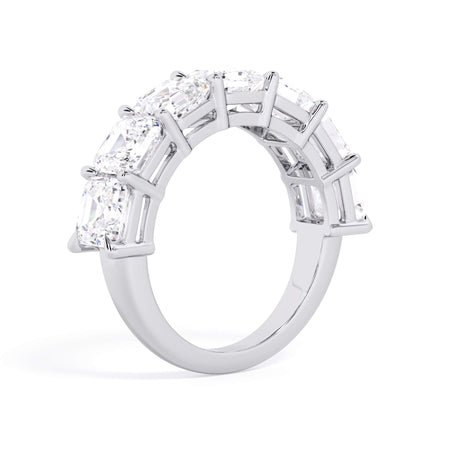 A picture of a seven stone diamond wedding ring with asscher cut diamonds that are shared prong set in white gold or platinum on a white background with a slightly angled, through the finger view.