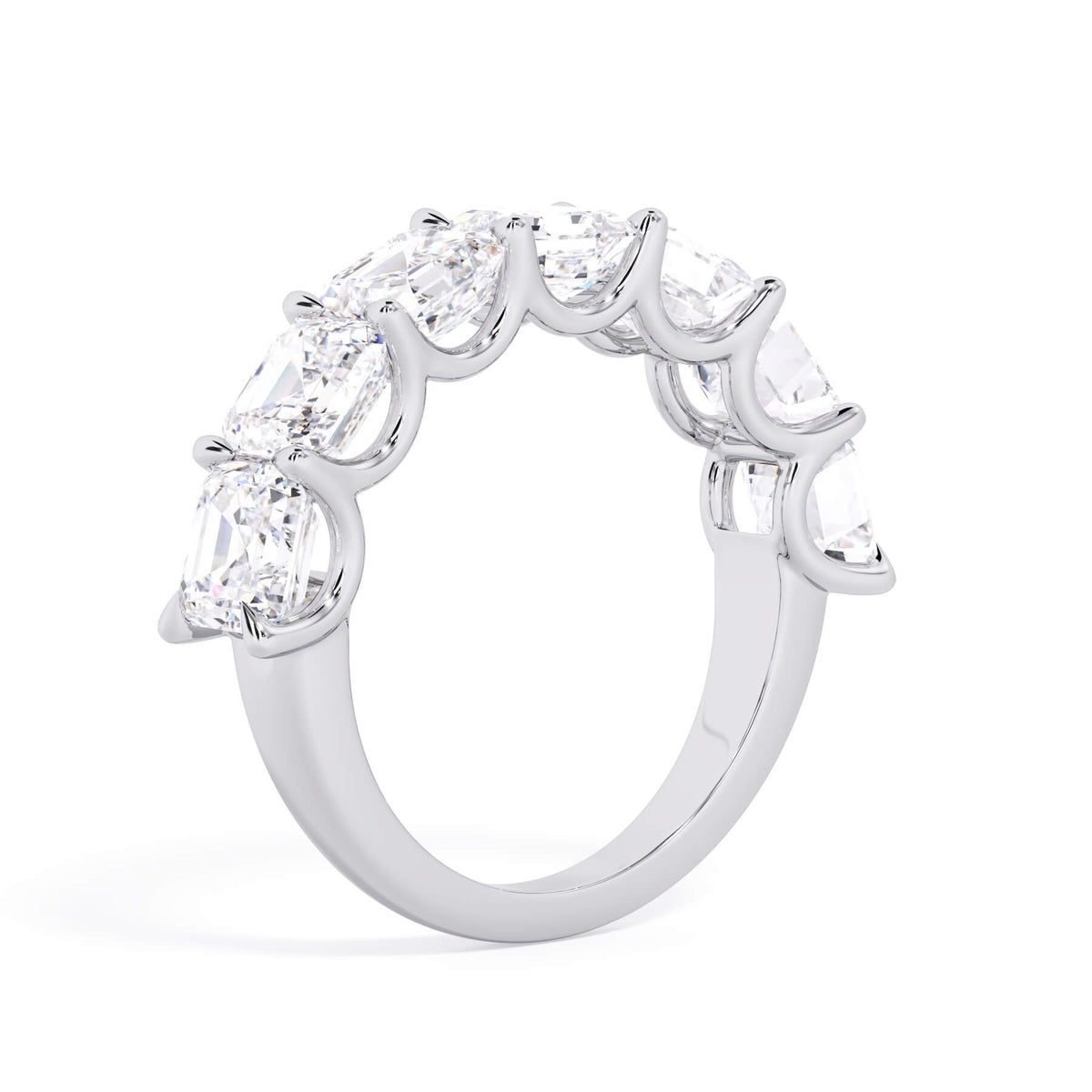 A picture of a seven stone diamond wedding ring with asscher cut diamonds that are U prong set in white gold or platinum on a white background with a slightly angled, through the finger view.