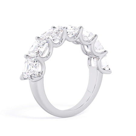 A picture of a seven stone diamond wedding ring with asscher cut diamonds that are U prong set in white gold or platinum on a white background with a slightly angled, through the finger view.