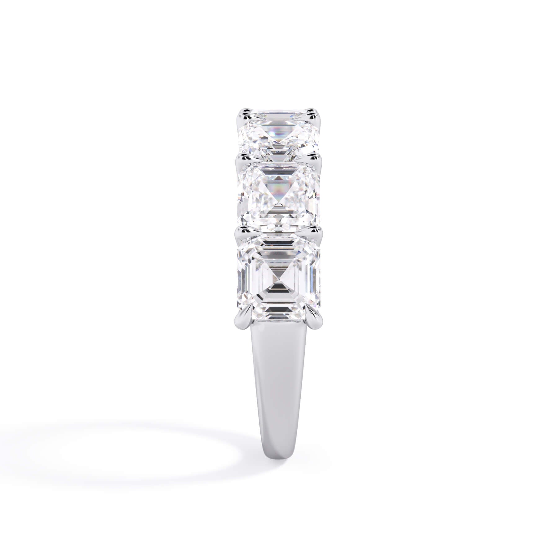 A picture of a seven stone diamond wedding ring with asscher cut diamonds that are U prong set in white gold or platinum on a white background with a side profile view.