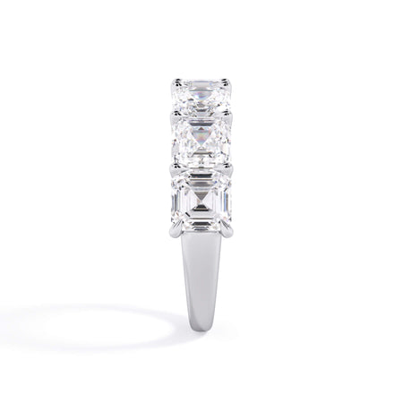 A picture of a seven stone diamond wedding ring with asscher cut diamonds that are U prong set in white gold or platinum on a white background with a side profile view.