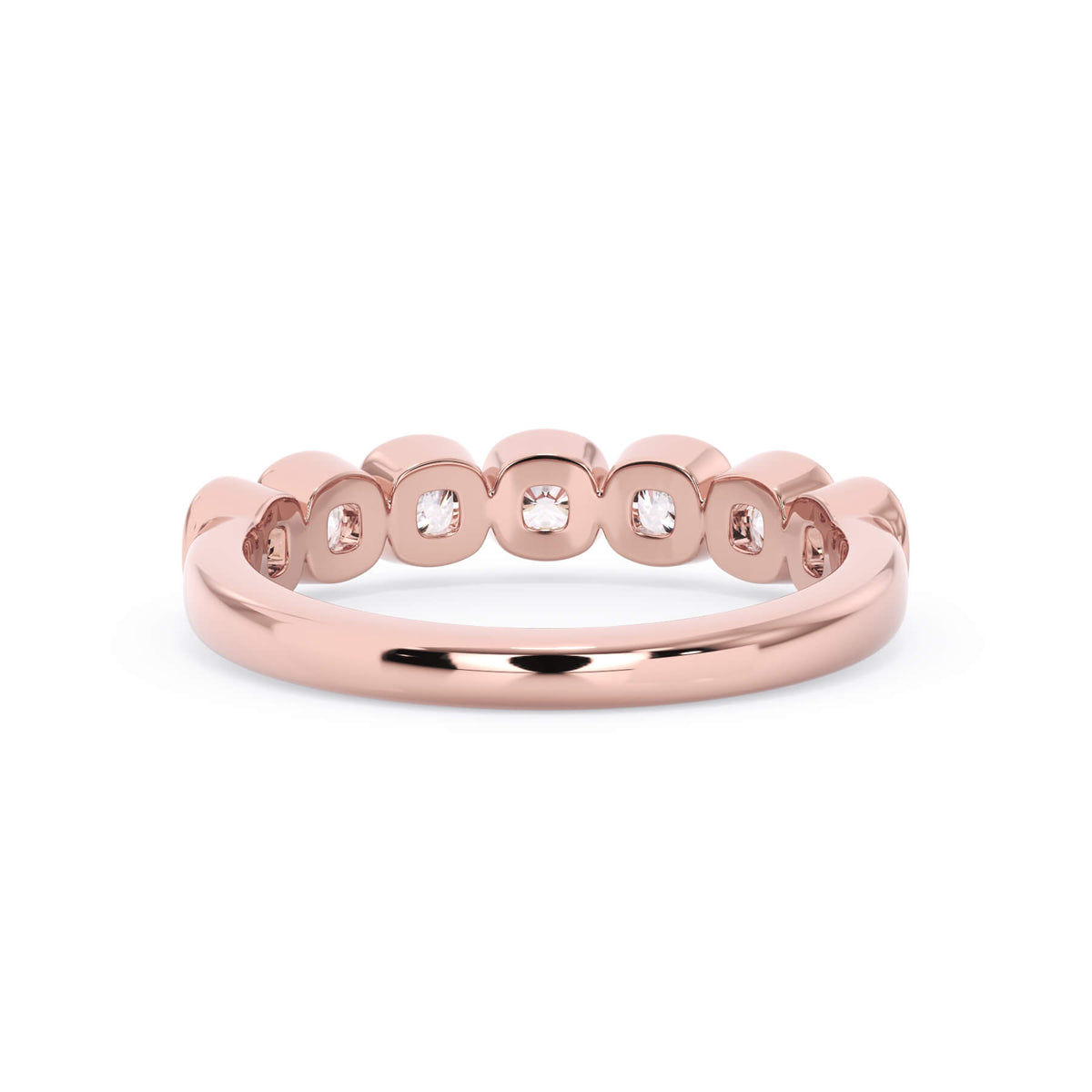 A picture of a seven stone diamond wedding ring with cushion cut diamonds that are bezel set in rose gold on a white background with a view of the underside of the ring.