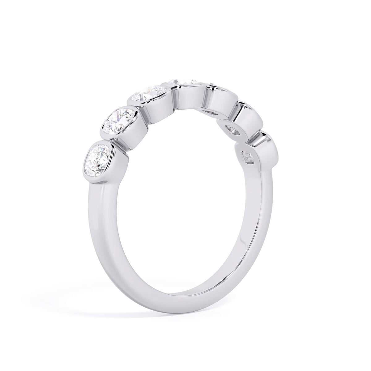 A picture of a seven stone diamond wedding ring with cushion cut diamonds that are bezel set in white gold or platinum on a white background with a slightly angled, through the finger view.