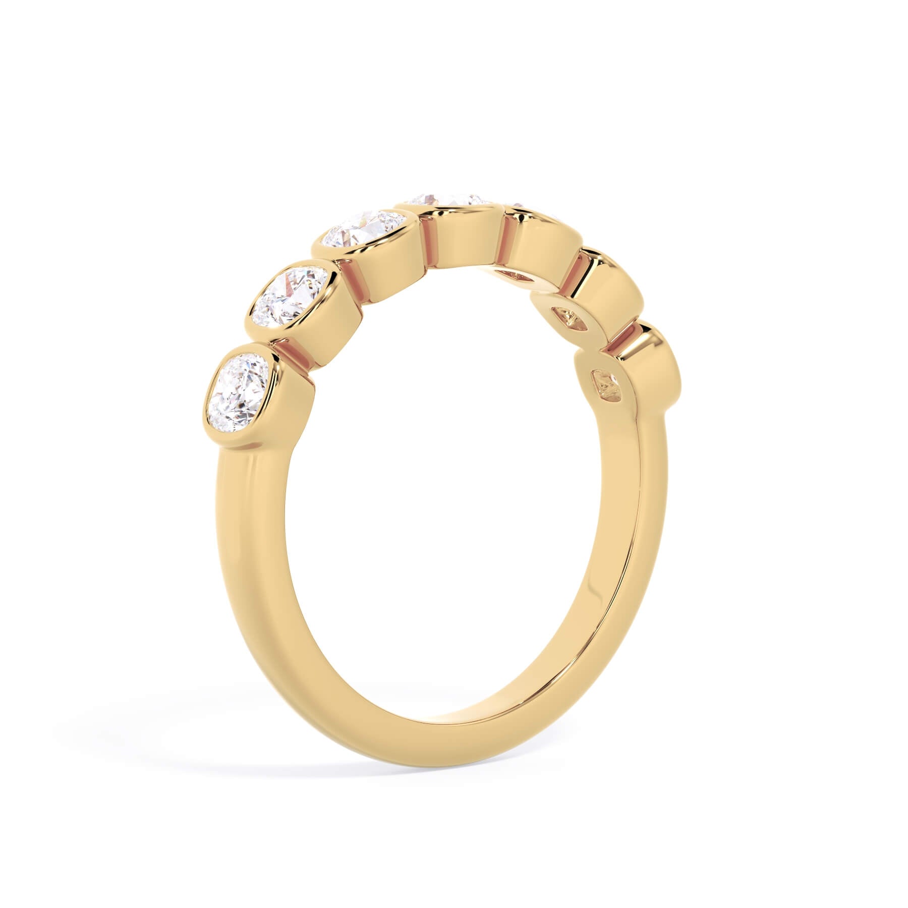 A picture of a seven stone diamond wedding ring with cushion cut diamonds that are bezel set in yellow gold on a white background with a slightly angled, through the finger view.