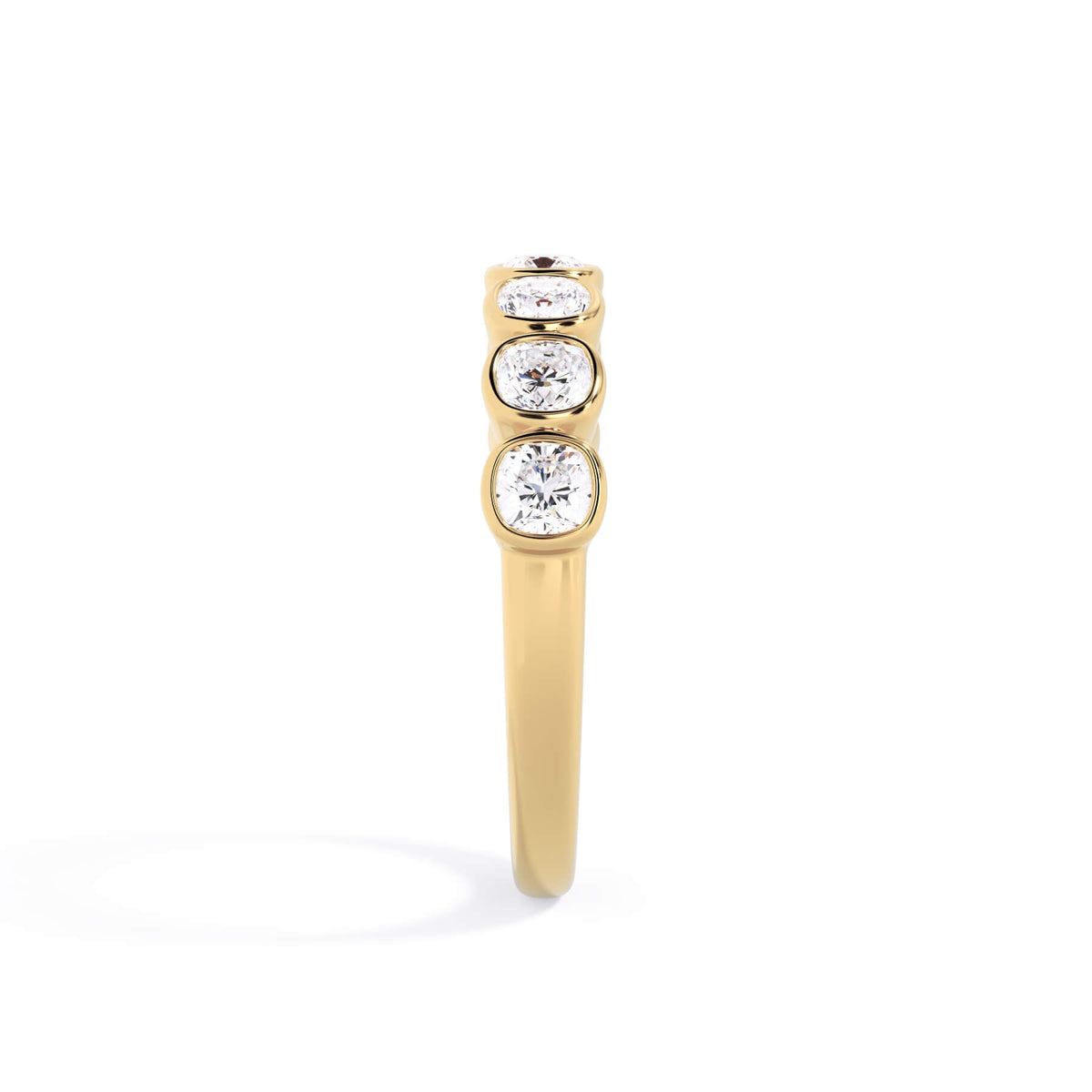 A picture of a seven stone diamond wedding ring with cushion cut diamonds that are bezel set in yellow gold on a white background with a side profile view.