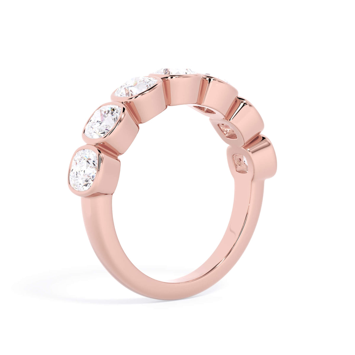 A picture of a seven stone diamond wedding ring with cushion cut diamonds that are bezel set in rose gold on a white background with the ring facing forward, lying down.