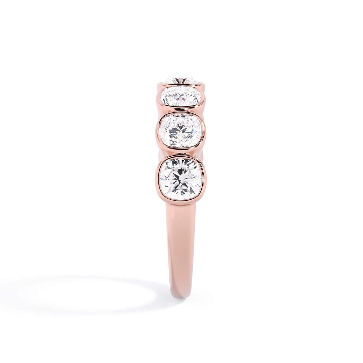 A picture of a seven stone diamond wedding ring with cushion cut diamonds that are bezel set in rose gold on a white background with the ring facing forward, lying down.