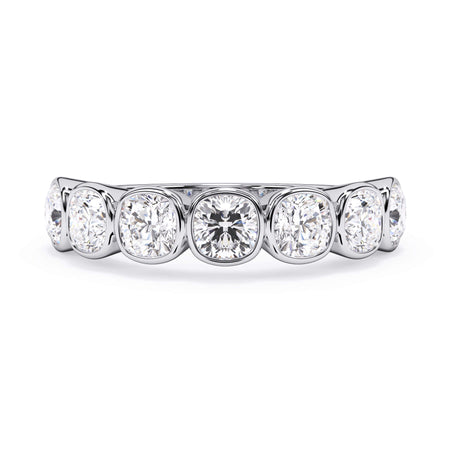 A picture of a seven stone diamond wedding ring with cushion cut diamonds that are bezel set in white gold or platinum on a white background with the ring facing forward, lying down.