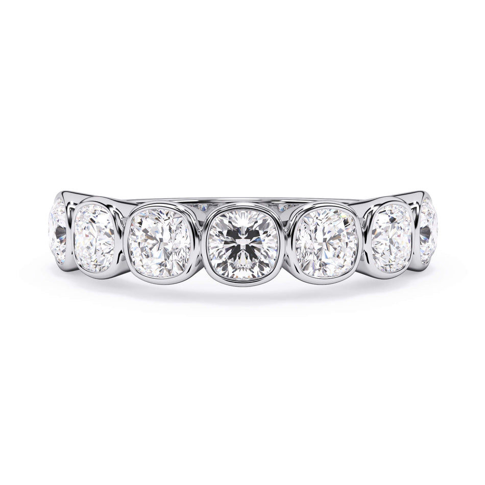 A picture of a seven stone diamond wedding ring with cushion cut diamonds that are bezel set in white gold or platinum on a white background with the ring facing forward, lying down.