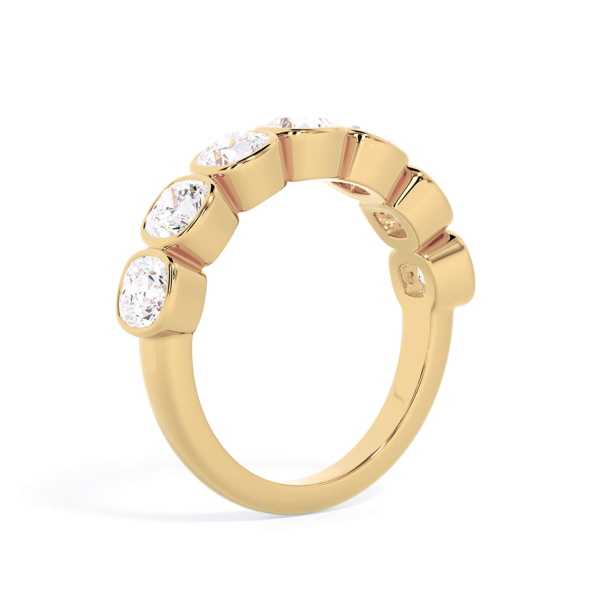 A picture of a seven stone diamond wedding ring with cushion cut diamonds that are bezel set in yellow gold on a white background with a slightly angled, through the finger view.