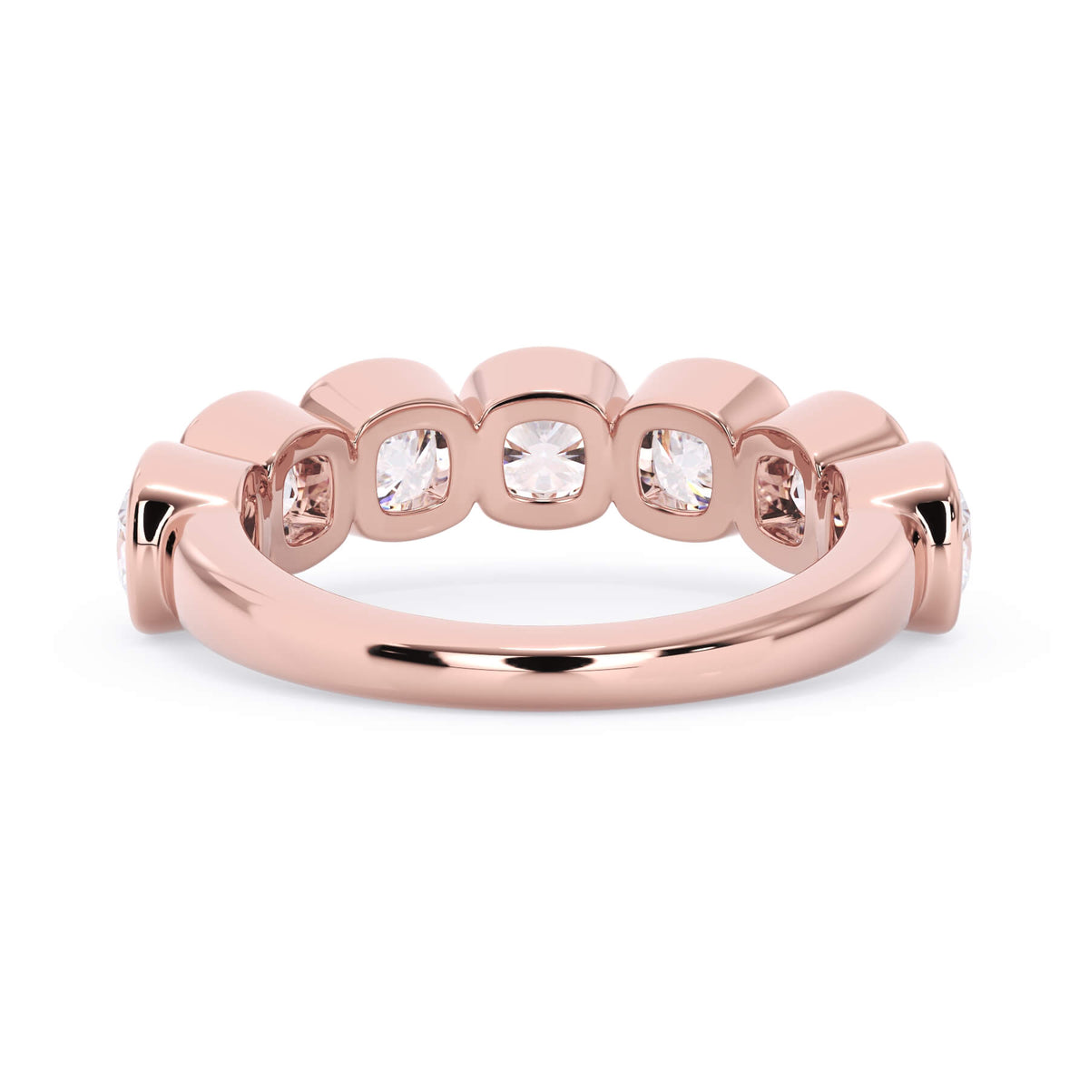 A picture of a seven stone diamond wedding ring with cushion cut diamonds that are bezel set in rose gold on a white background with a view of the underside of the ring.