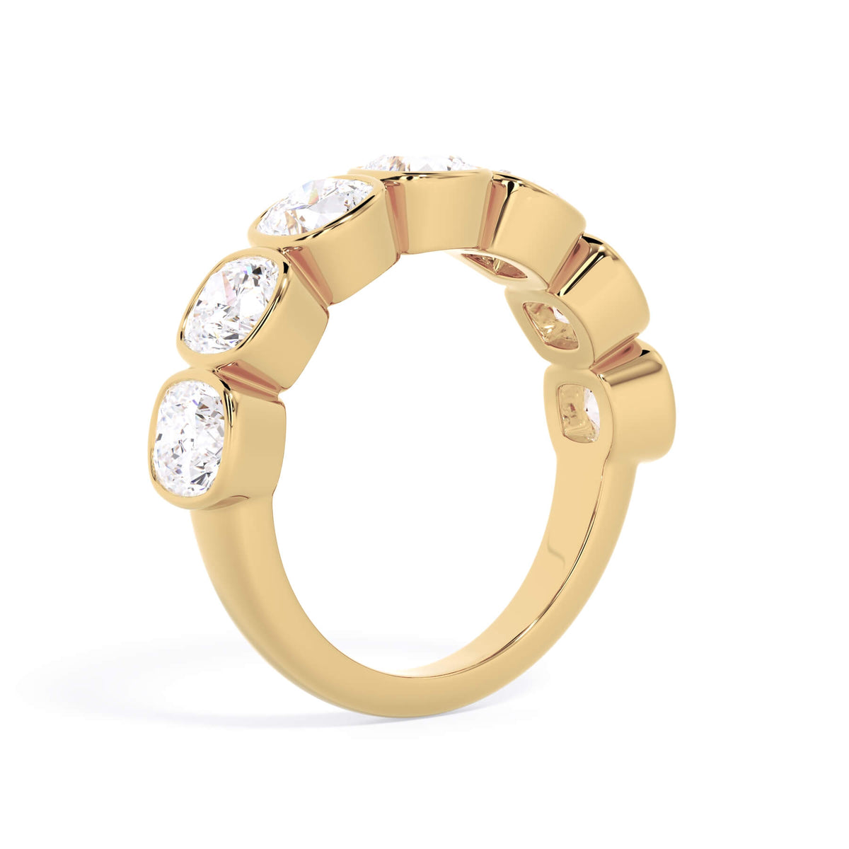 A picture of a seven stone diamond wedding ring with cushion cut diamonds that are bezel set in yellow gold on a white background with a slightly angled, through the finger view.