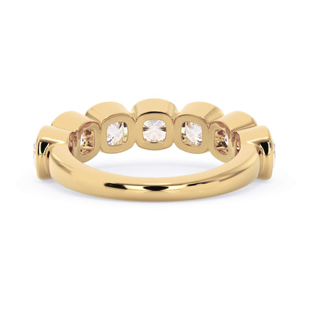 A picture of a seven stone diamond wedding ring with cushion cut diamonds that are bezel set in yellow gold on a white background with a view of the underside of the ring.