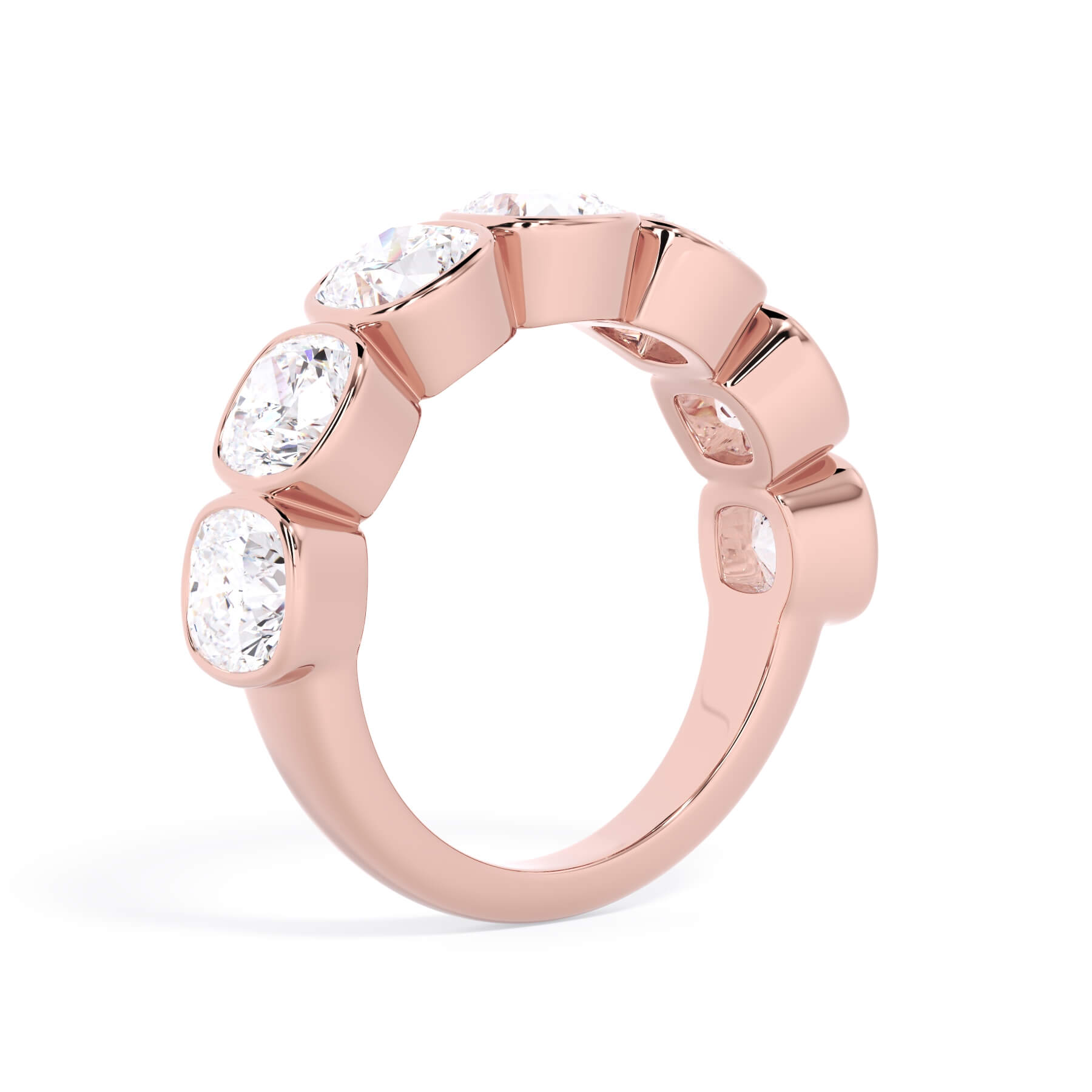 A picture of a seven stone diamond wedding ring with cushion cut diamonds that are bezel set in rose gold on a white background with a slightly angled, through the finger view.