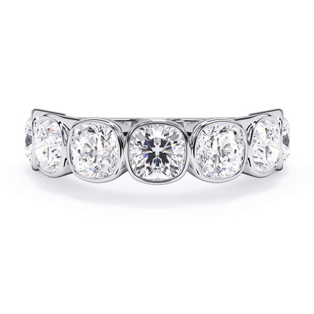 A picture of a seven stone diamond wedding ring with cushion cut diamonds that are bezel set in white gold or platinum on a white background with the ring facing forward, lying down.