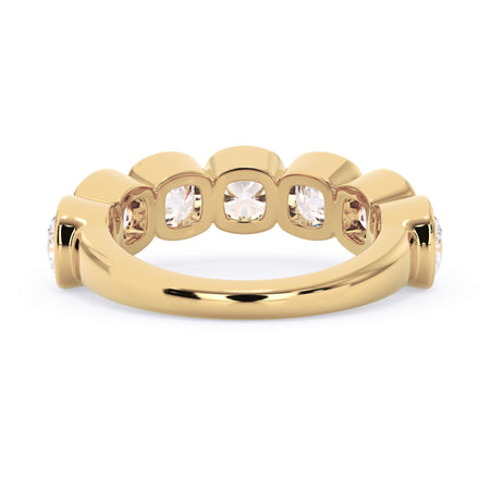 A picture of a seven stone diamond wedding ring with cushion cut diamonds that are bezel set in yellow gold on a white background with a view of the underside of the ring.