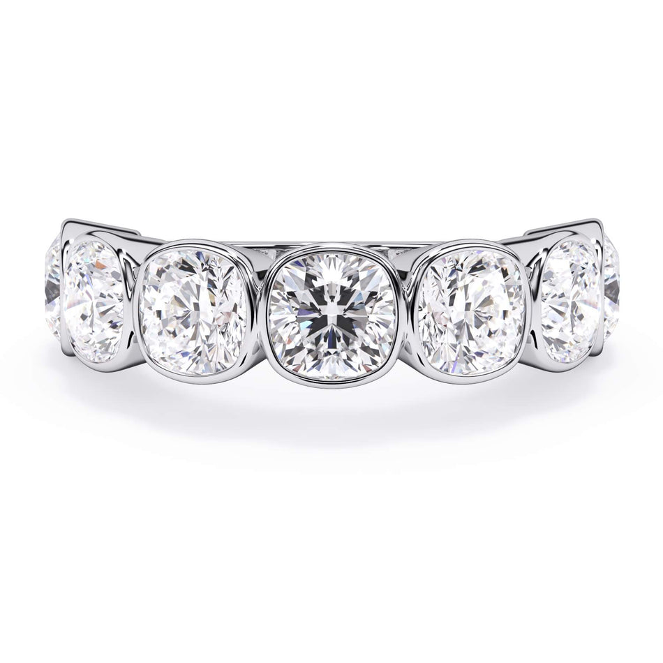 A picture of a seven stone diamond wedding ring with cushion cut diamonds that are bezel set in white gold or platinum on a white background with the ring facing forward, lying down.