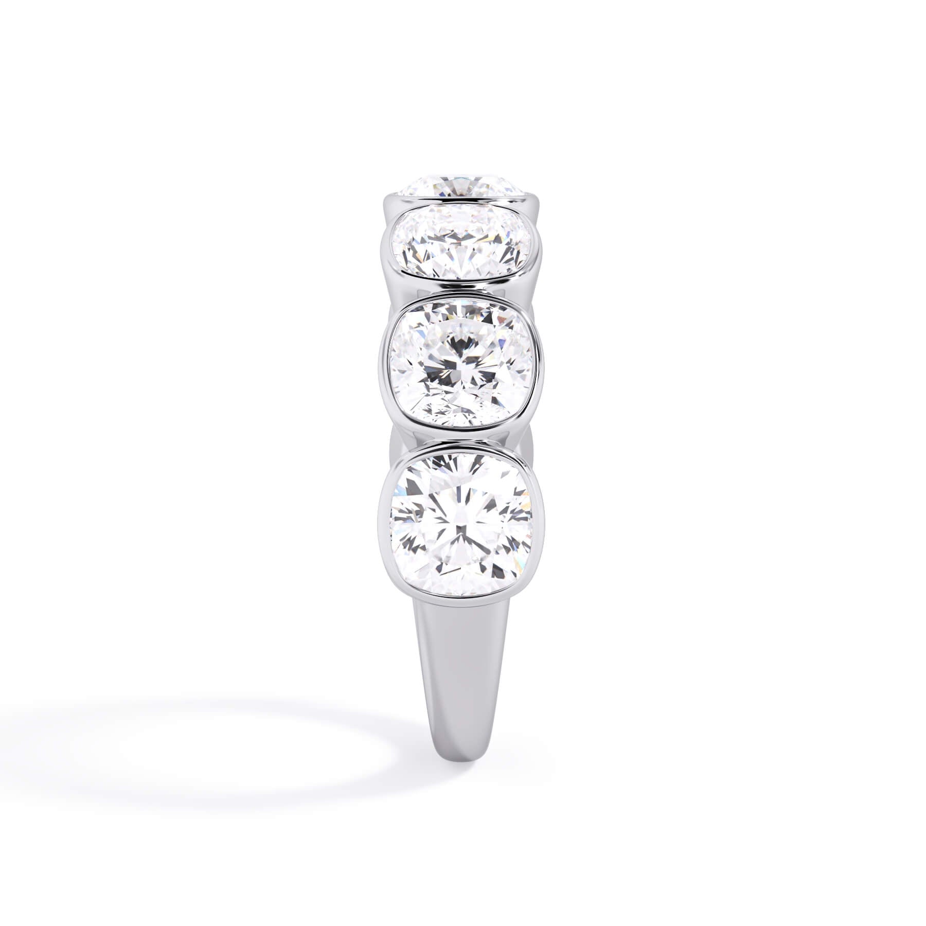 A picture of a seven stone diamond wedding ring with cushion cut diamonds that are bezel set in white gold or platinum on a white background with a side profile view.