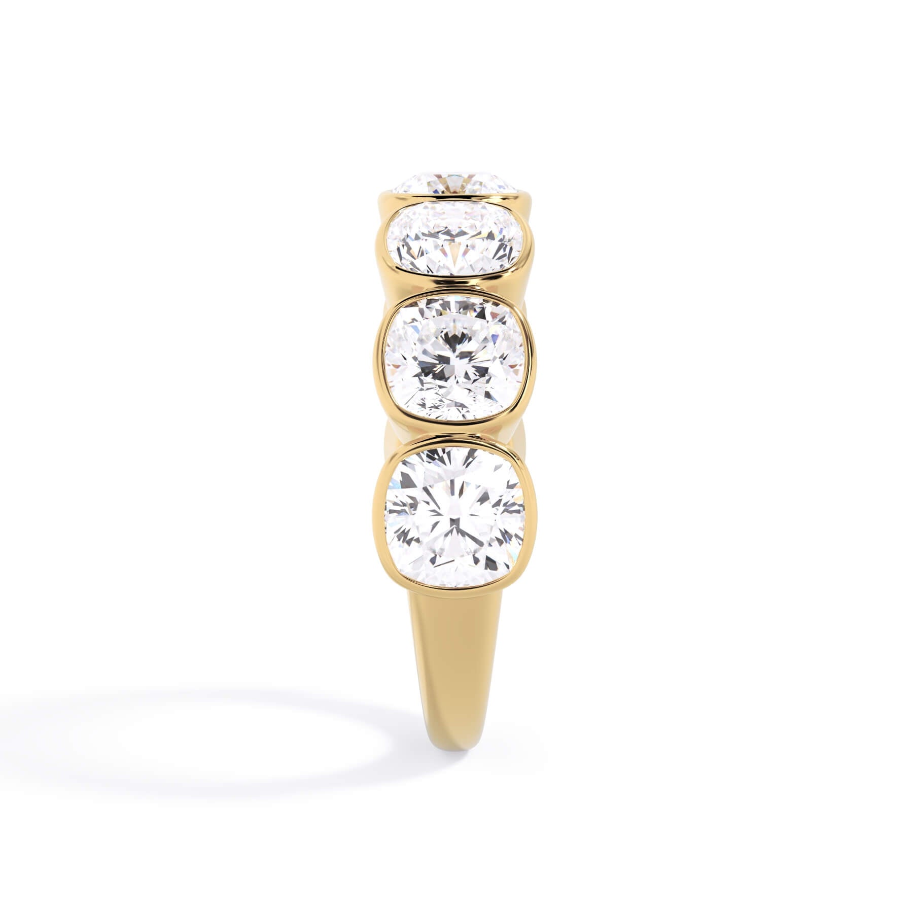 A picture of a seven stone diamond wedding ring with cushion cut diamonds that are bezel set in yellow gold on a white background with a side profile view.