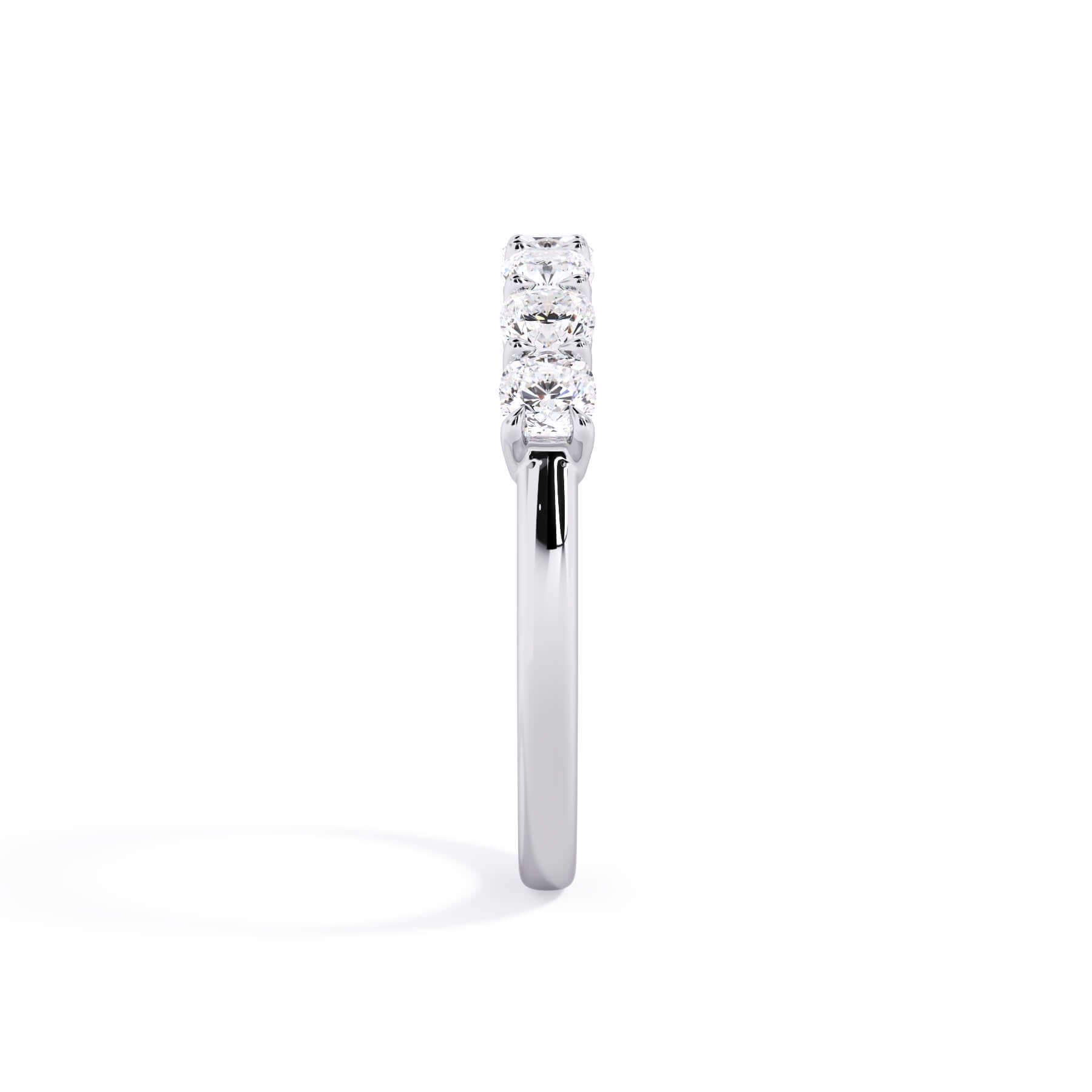 A picture of a seven stone diamond wedding ring with cushion cut diamonds that are shared prong set in white gold or platinum on a white background with a side profile view.