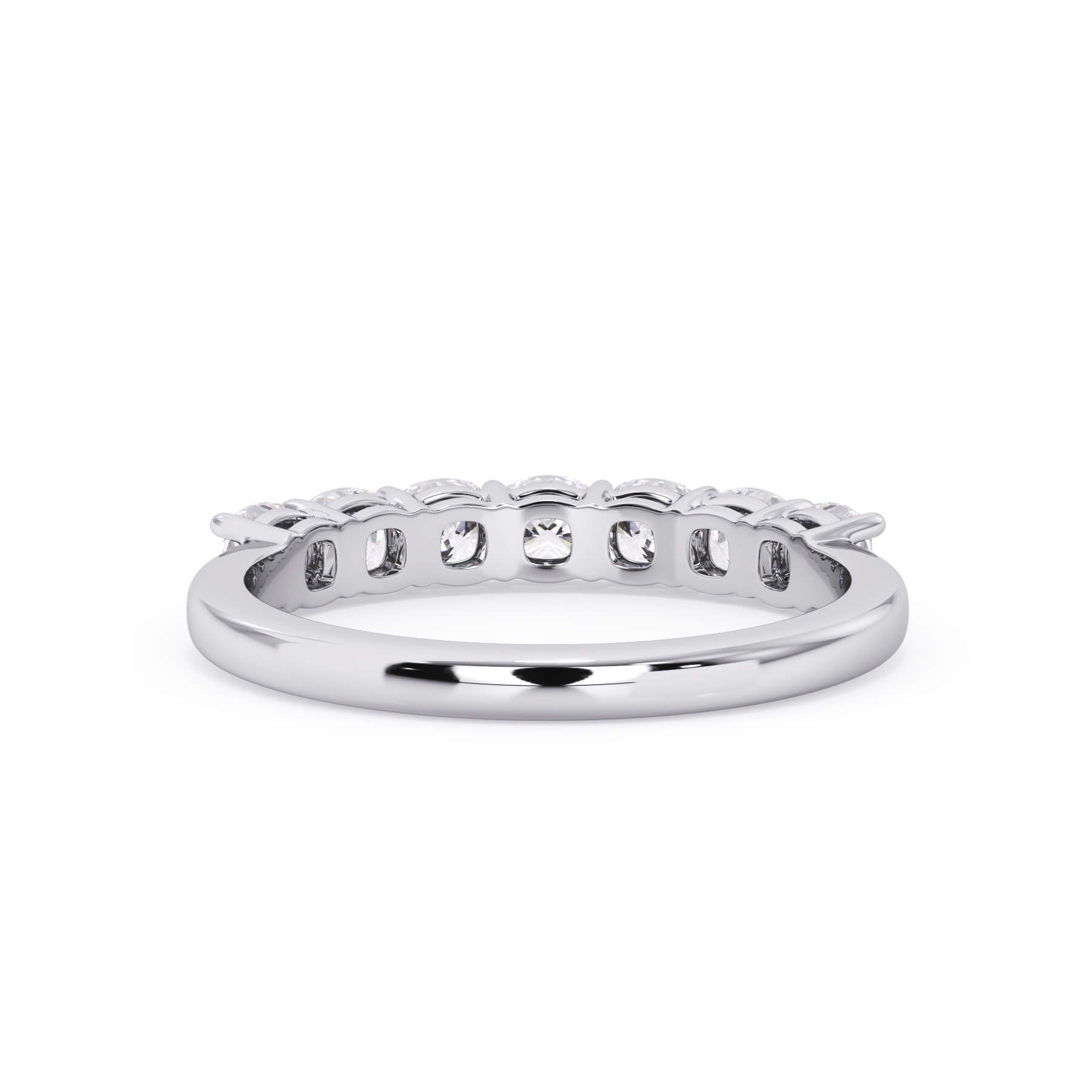 A picture of a seven stone diamond wedding ring with cushion cut diamonds that are shared prong set in white gold or platinum on a white background with a view of the underside of the ring.