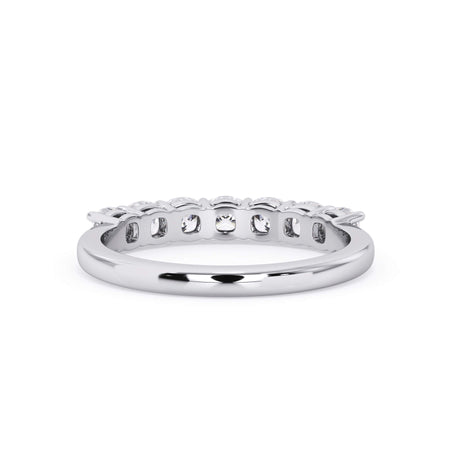 A picture of a seven stone diamond wedding ring with cushion cut diamonds that are shared prong set in white gold or platinum on a white background with a view of the underside of the ring.