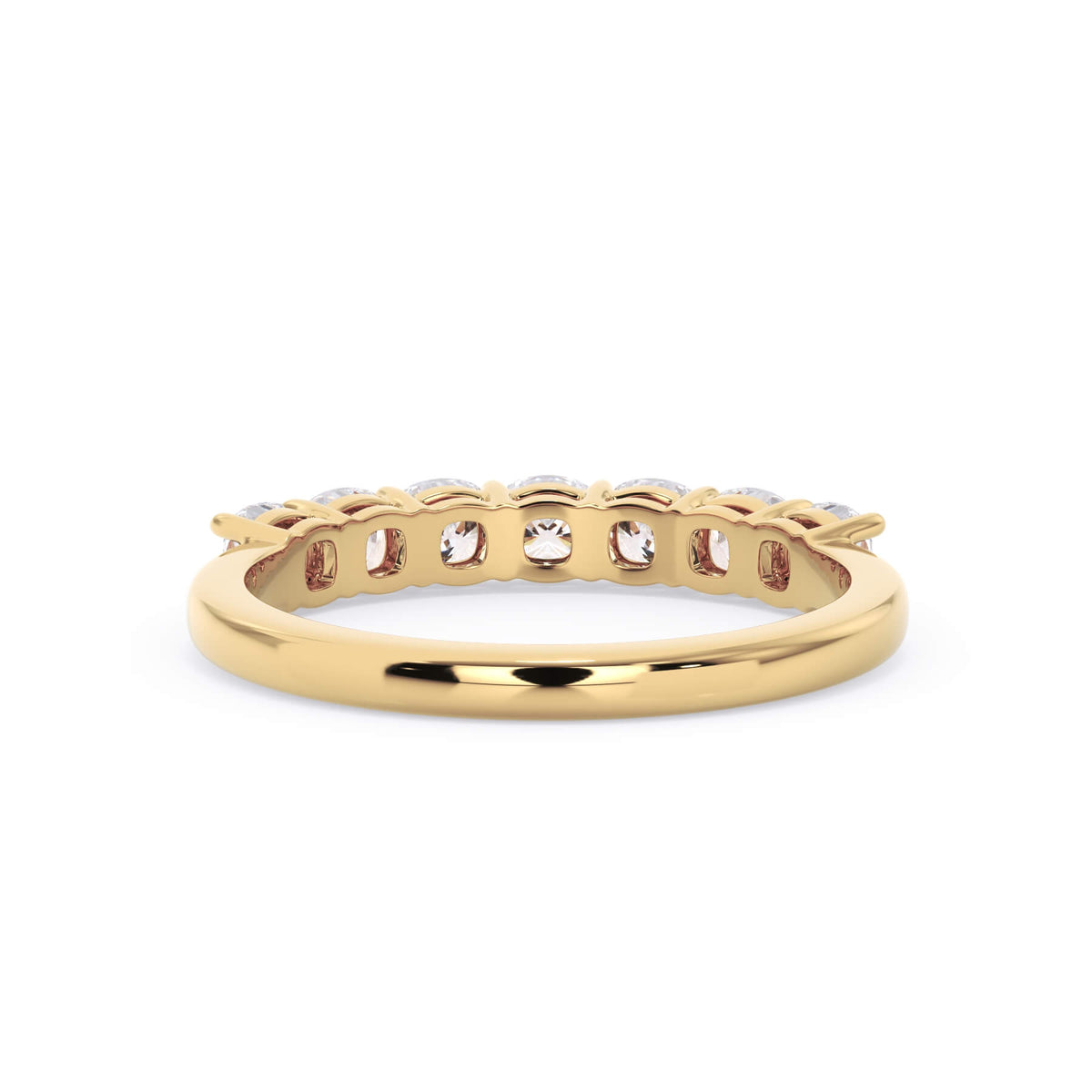 A picture of a seven stone diamond wedding ring with cushion cut diamonds that are shared prong set in yellow gold on a white background with a view of the underside of the ring.