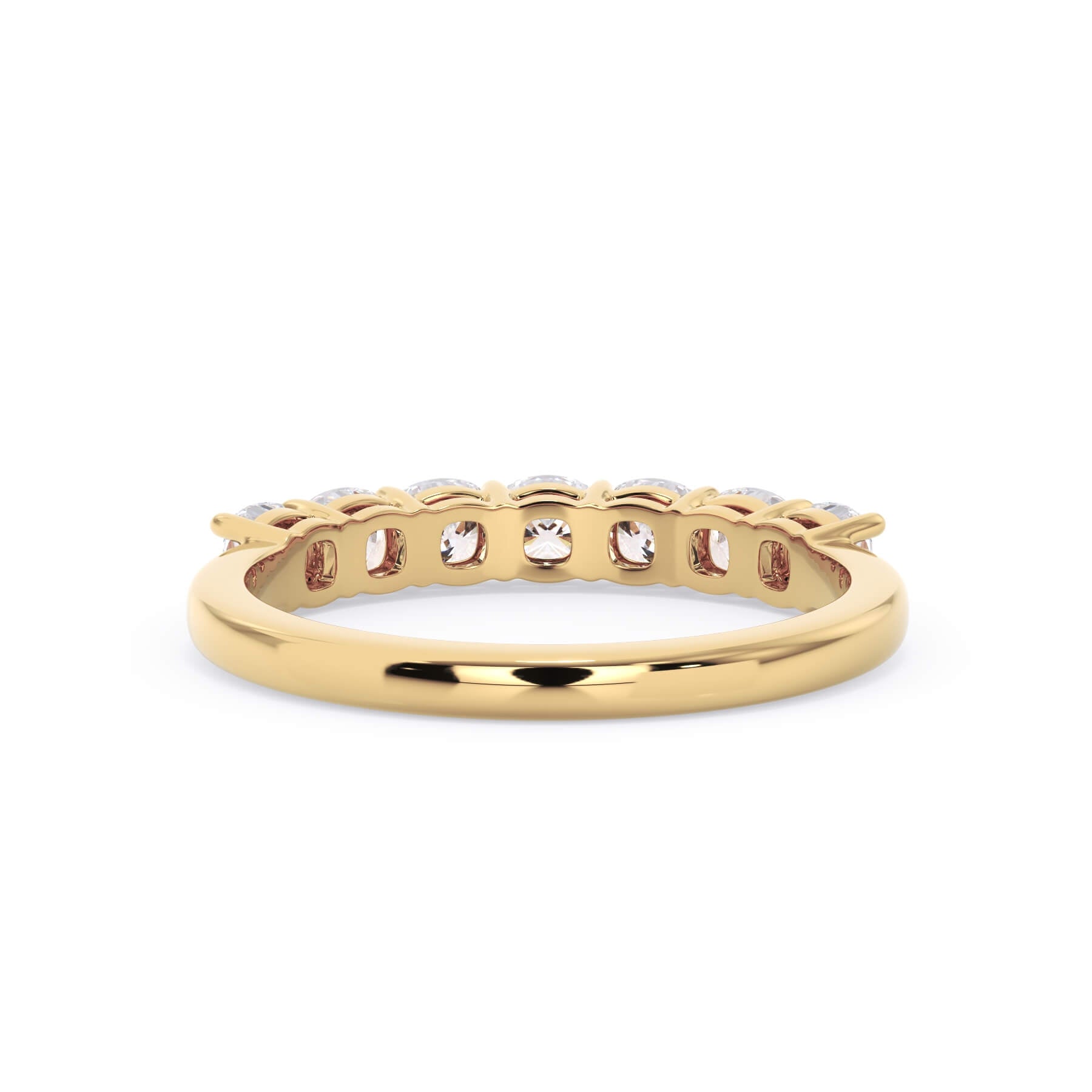 A picture of a seven stone diamond wedding ring with cushion cut diamonds that are shared prong set in yellow gold on a white background with a view of the underside of the ring.