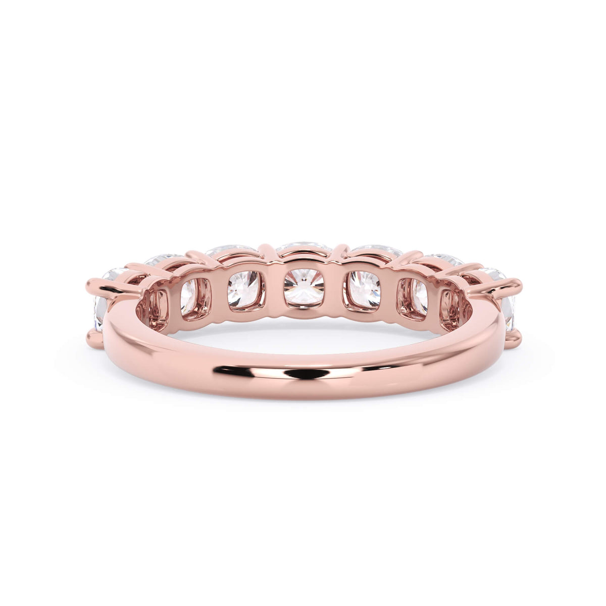 A picture of a seven stone diamond wedding ring with cushion cut diamonds that are shared prong set in rose gold on a white background with a view of the underside of the ring.