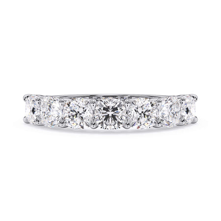 A picture of a seven stone diamond wedding ring with cushion cut diamonds that are shared prong set in white gold or platinum on a white background with the ring facing forward, lying down.