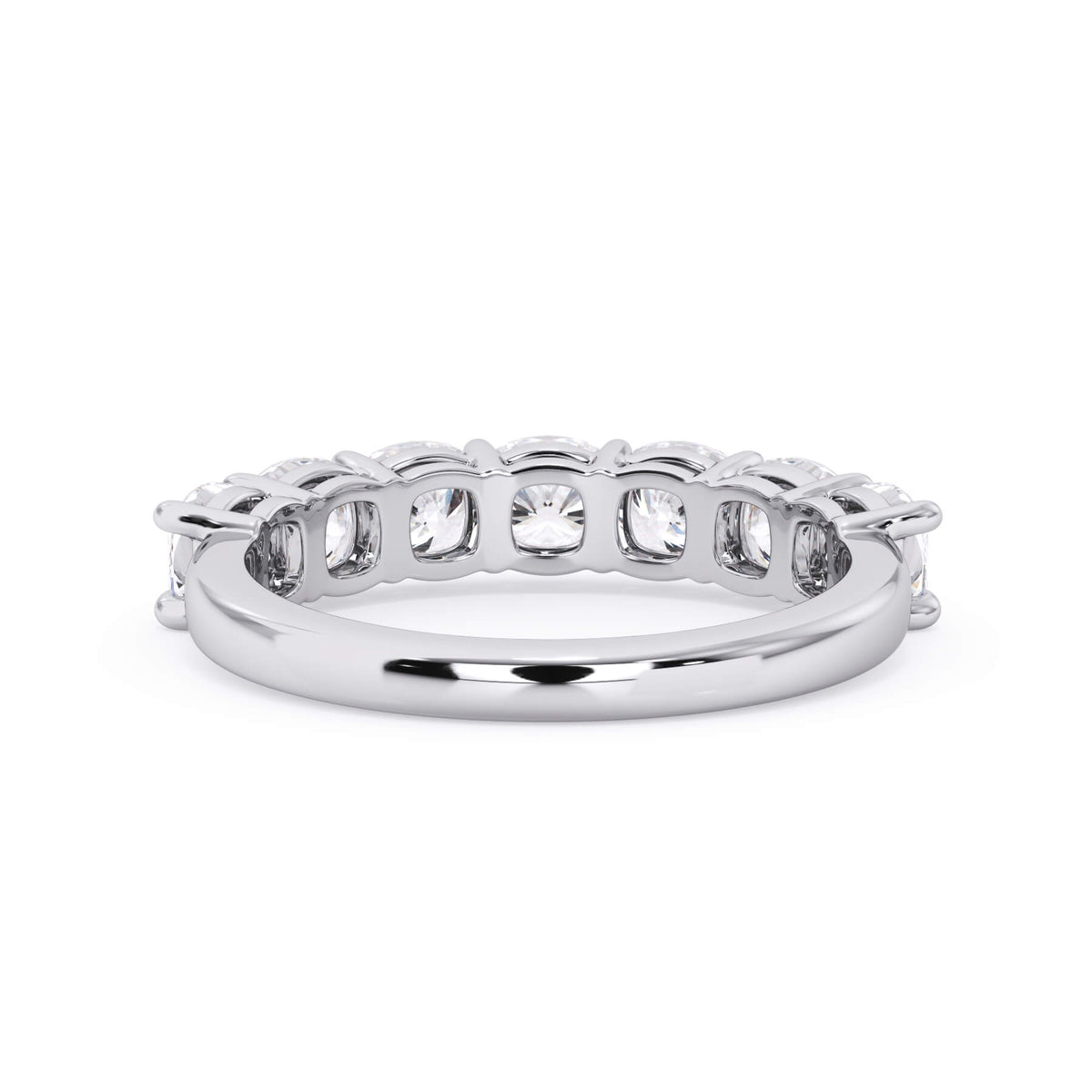A picture of a seven stone diamond wedding ring with cushion cut diamonds that are shared prong set in white gold or platinum on a white background with a view of the underside of the ring.