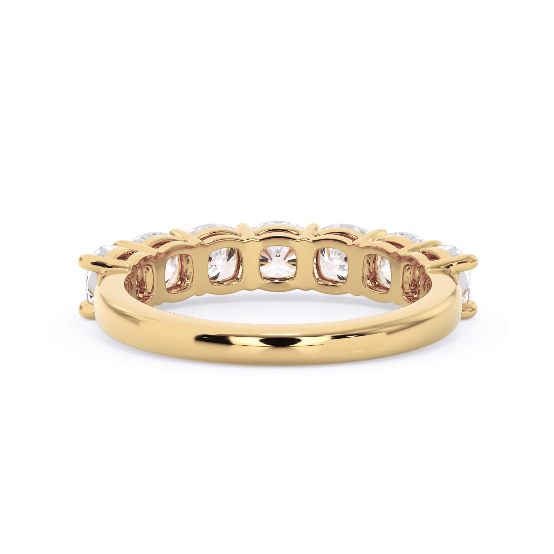 A picture of a seven stone diamond wedding ring with cushion cut diamonds that are shared prong set in yellow gold on a white background with a view of the underside of the ring.
