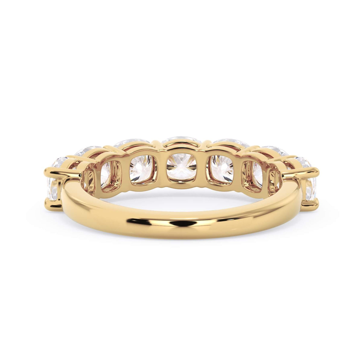 A picture of a seven stone diamond wedding ring with cushion cut diamonds that are shared prong set in yellow gold on a white background with a view of the underside of the ring.