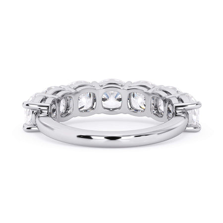 A picture of a seven stone diamond wedding ring with cushion cut diamonds that are shared prong set in white gold or platinum on a white background with a view of the underside of the ring.