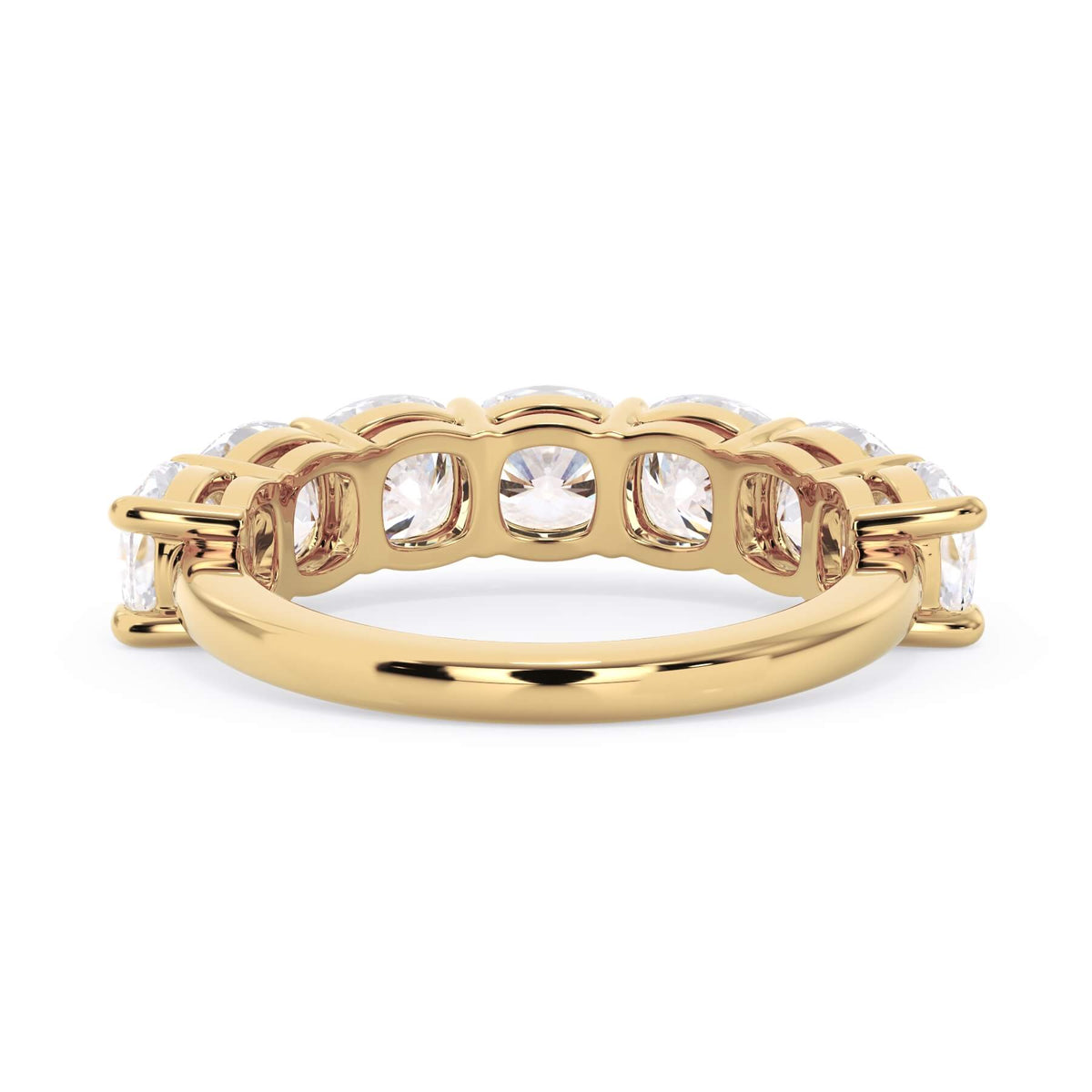 A picture of a seven stone diamond wedding ring with cushion cut diamonds that are shared prong set in yellow gold on a white background with a view of the underside of the ring.