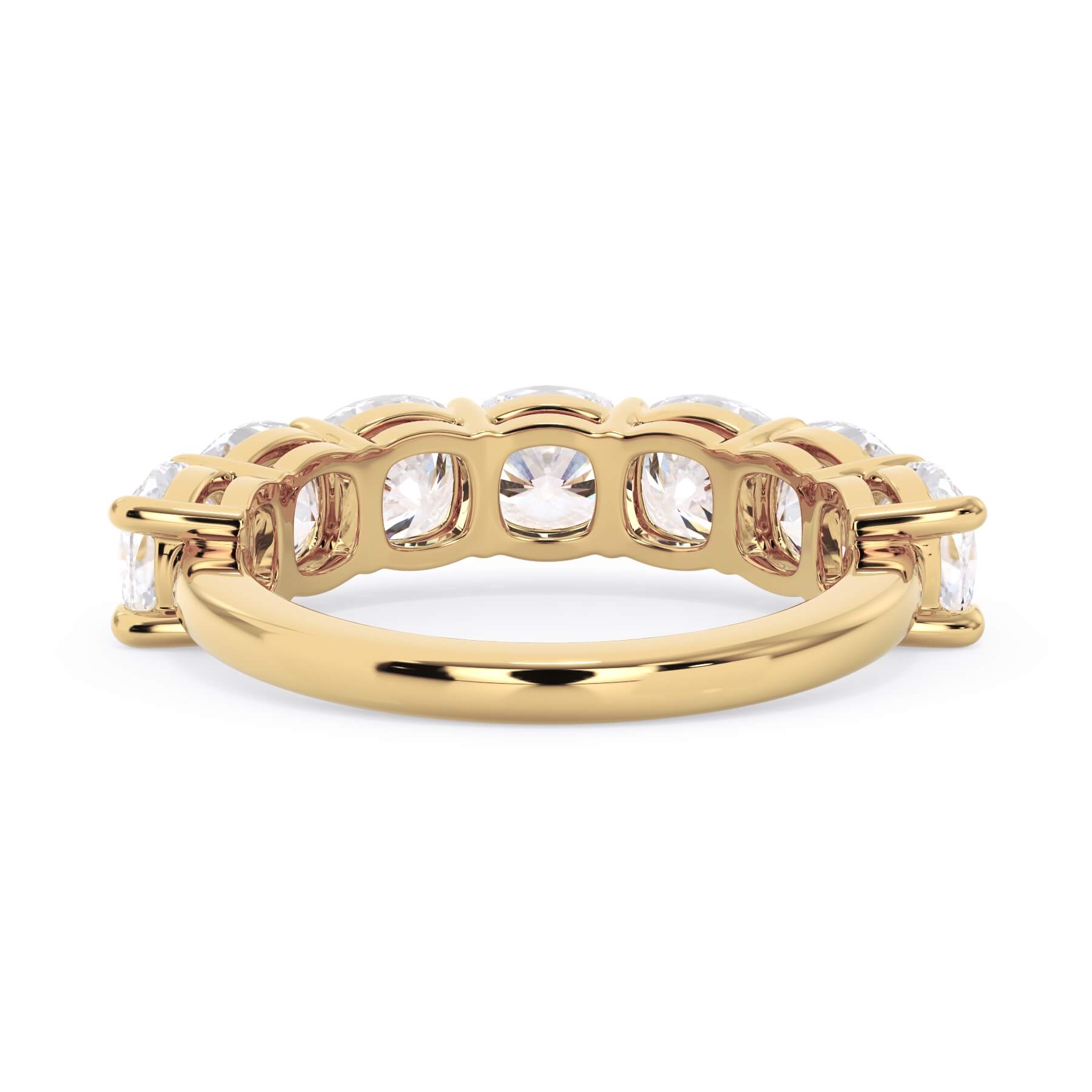 A picture of a seven stone diamond wedding ring with cushion cut diamonds that are shared prong set in yellow gold on a white background with a view of the underside of the ring.