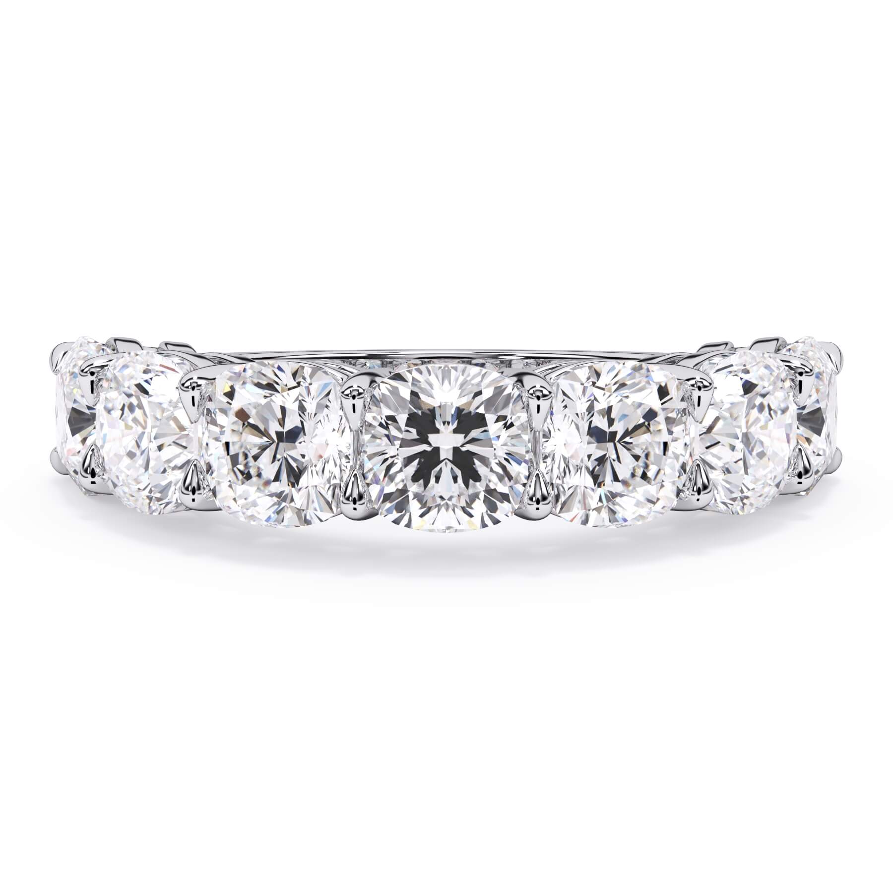 A picture of a seven stone diamond wedding ring with cushion cut diamonds that are shared prong set in white gold or platinum on a white background with the ring facing forward, lying down.
